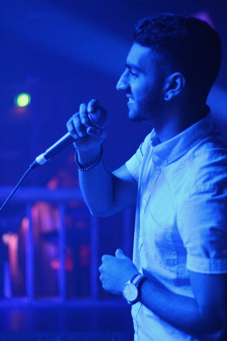 Amsal on the microphone in blue stage light